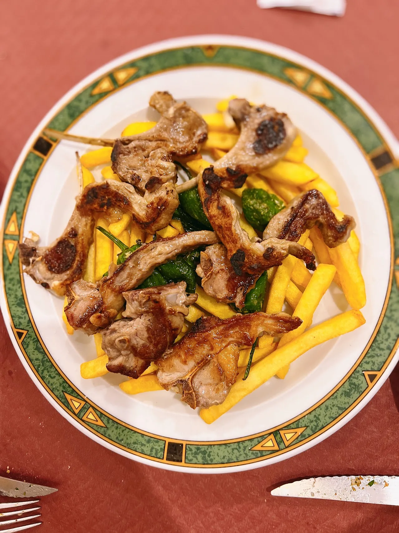 Grilled lamb chops with a side of fries and greens
