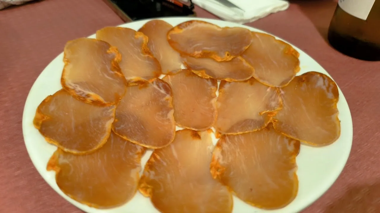 A plate of thinly sliced cured fish carpaccio
