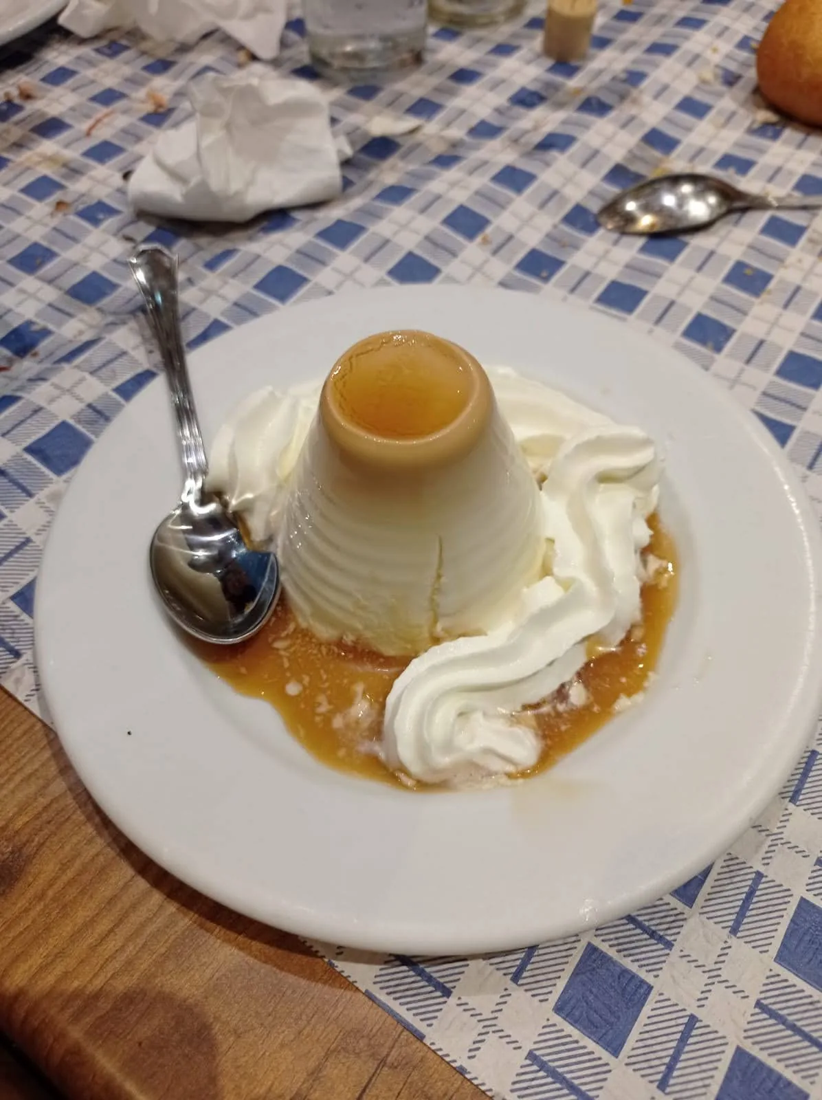 A caramel flan topped with whipped cream