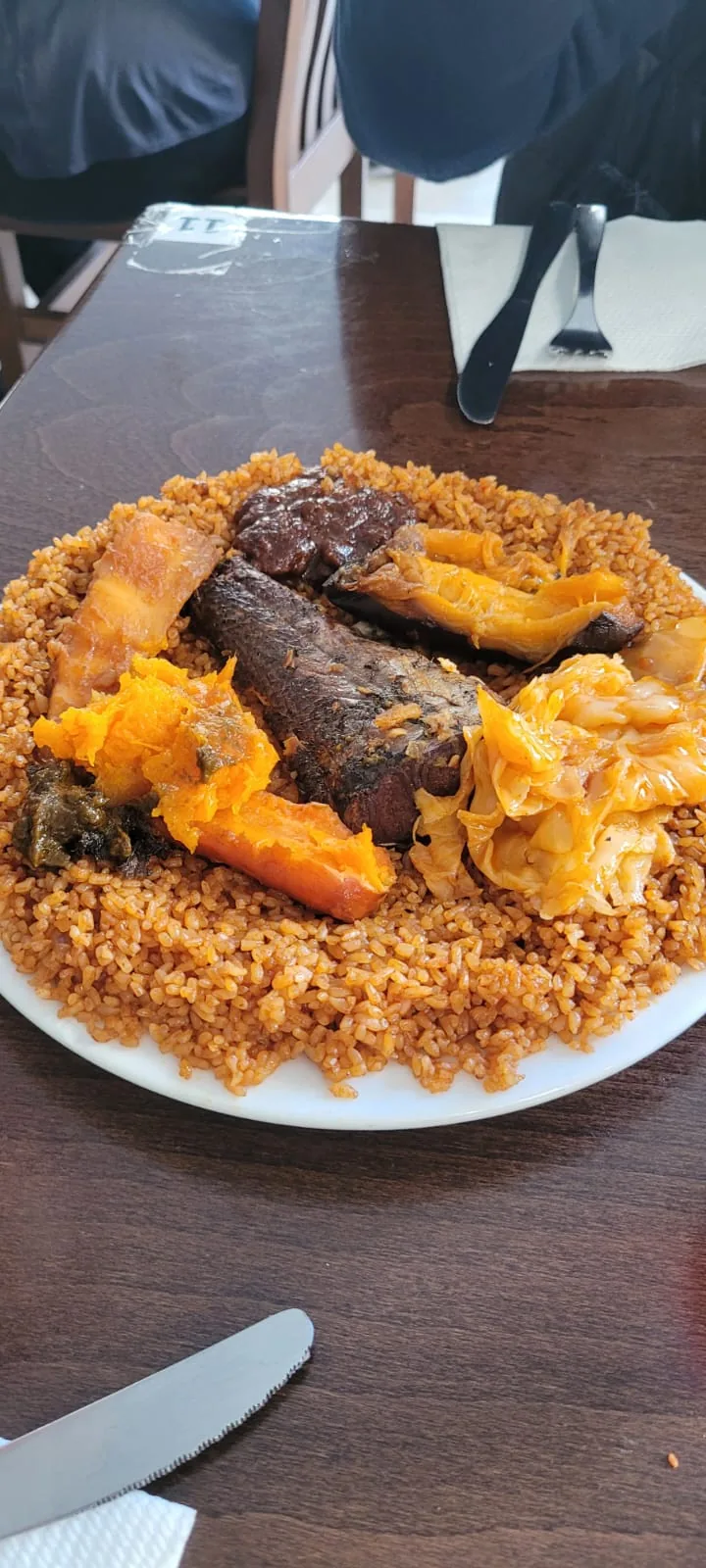 A plate of rice with grilled meat and stewed vegetables