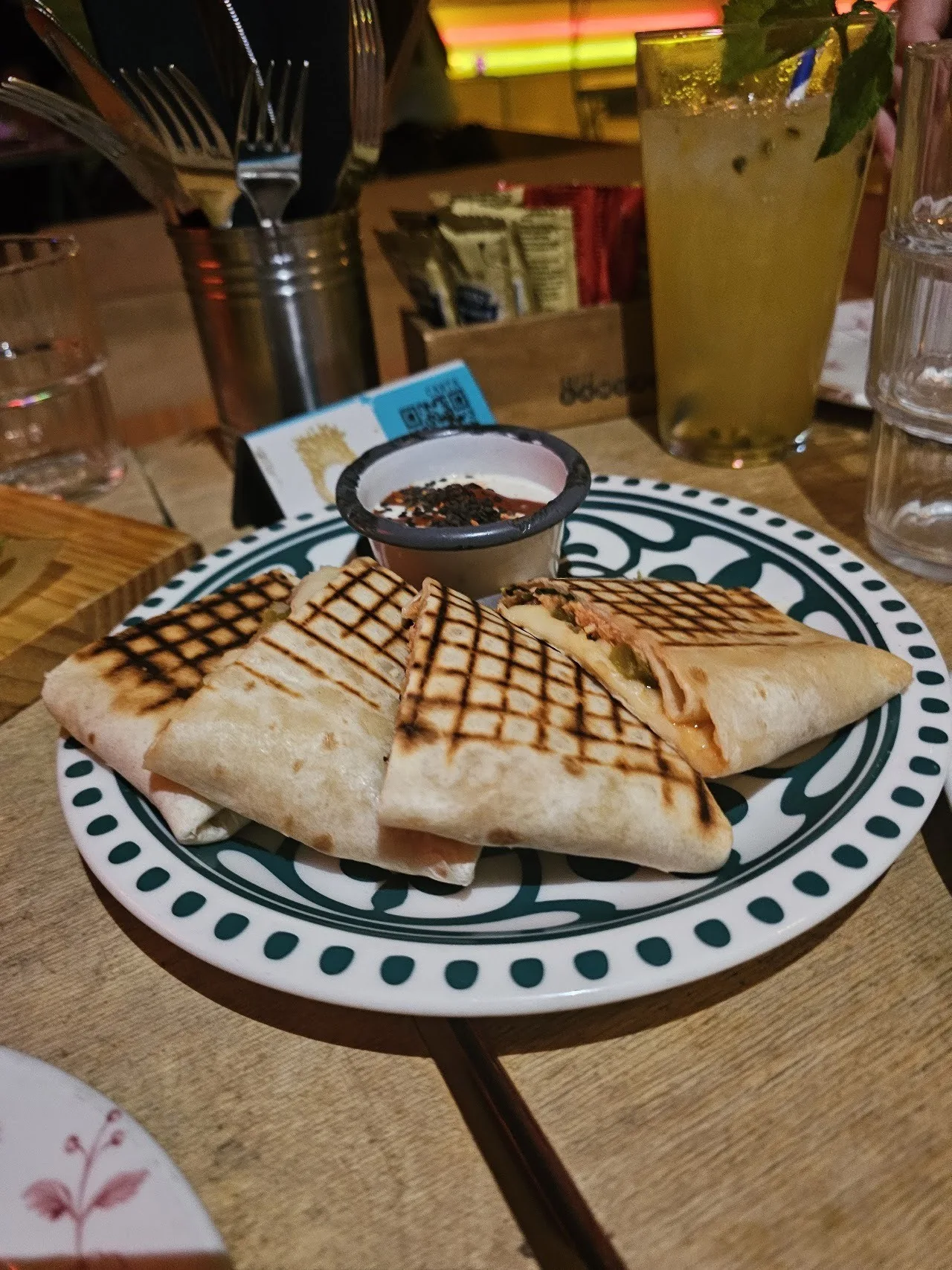 A grilled folded quesadilla on a patterned plate