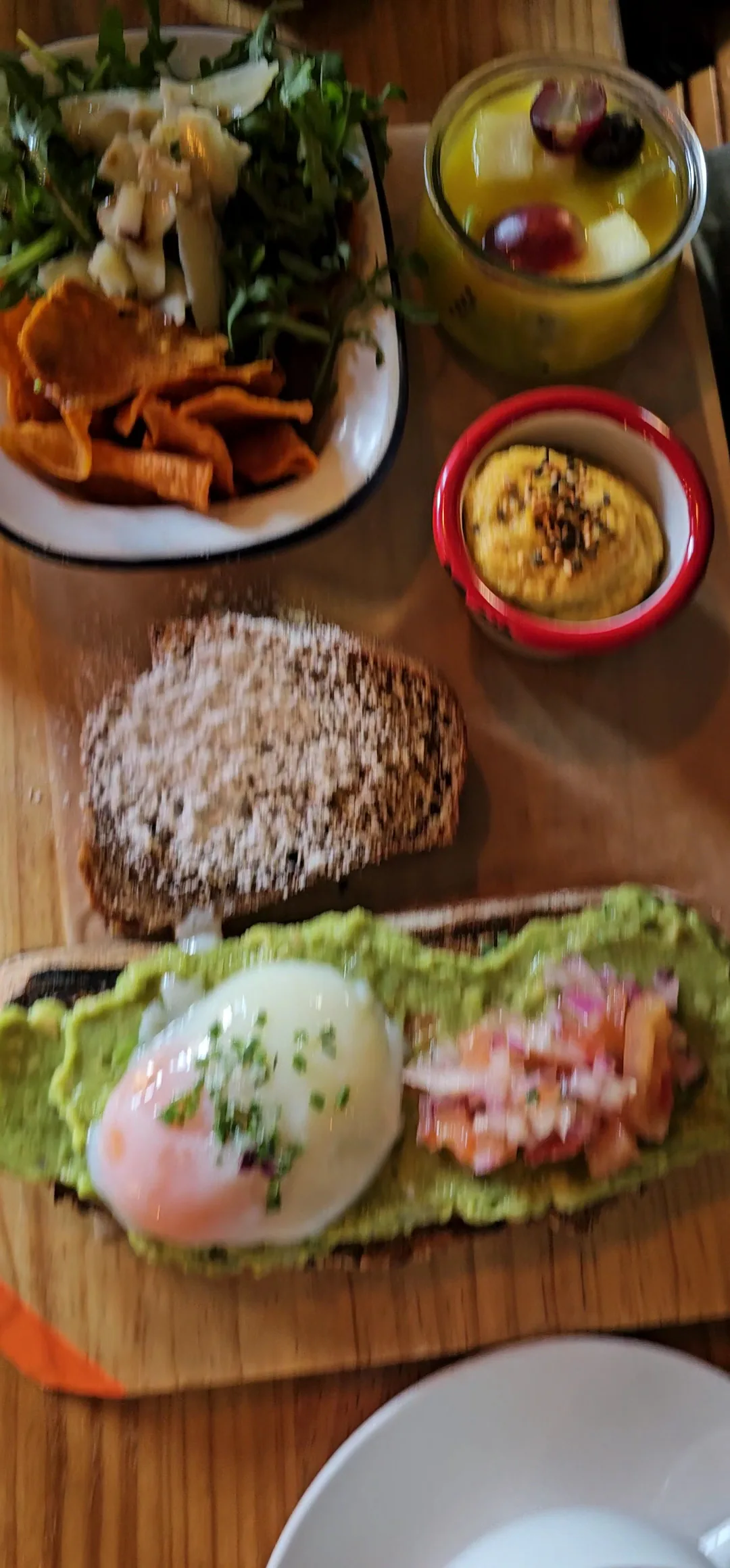A breakfast spread of avocado toast and small side dishes