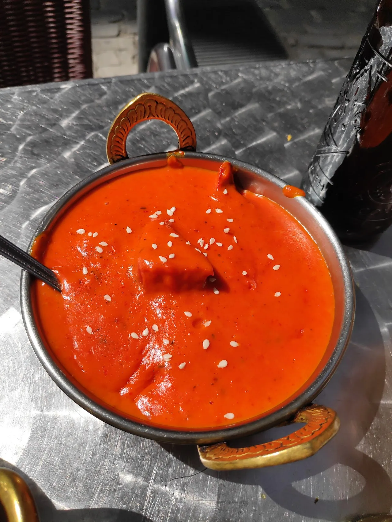 A copper bowl of orange curry sauce