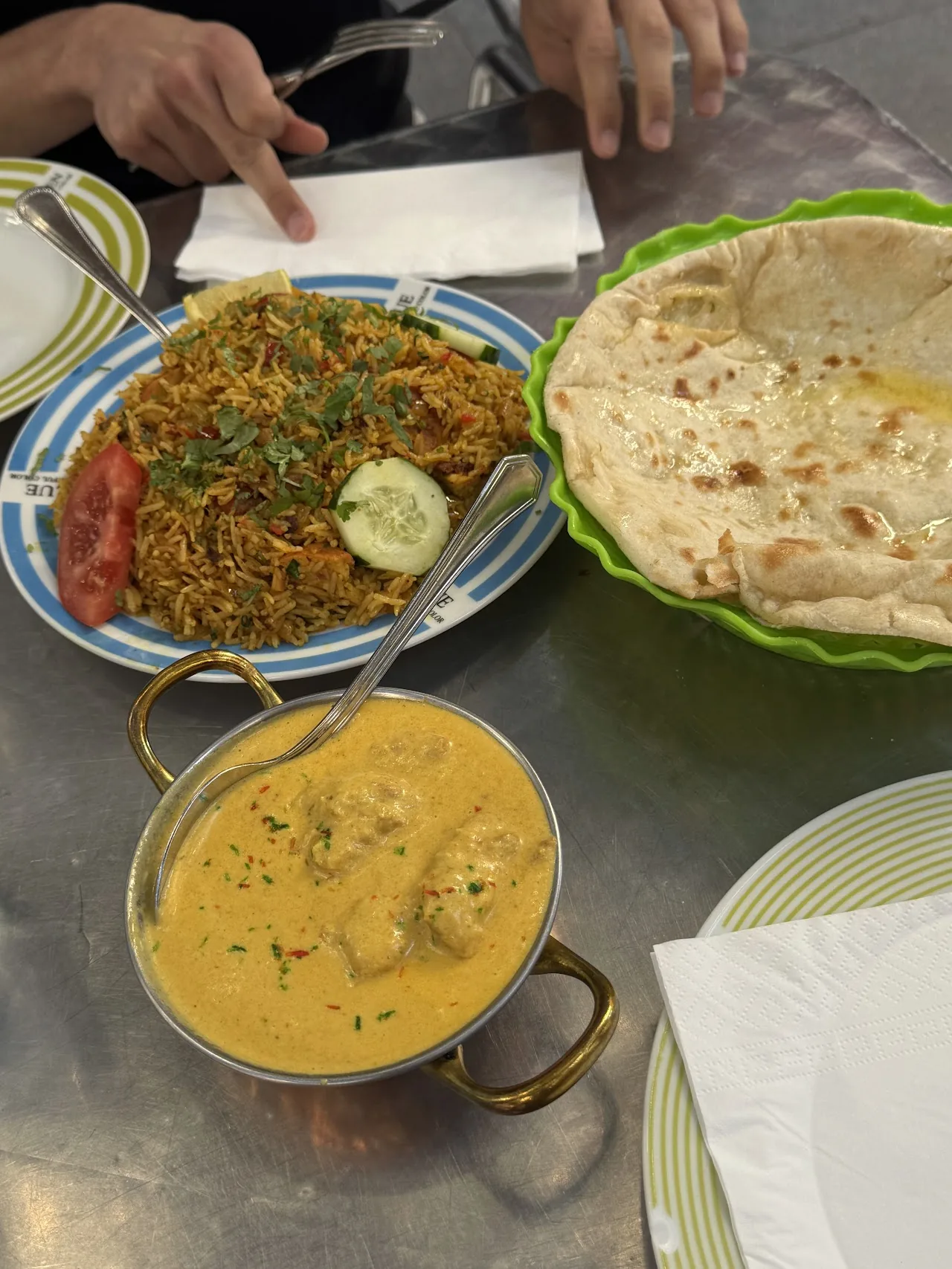A plate of fried rice noodles beside a bowl of yellow curry