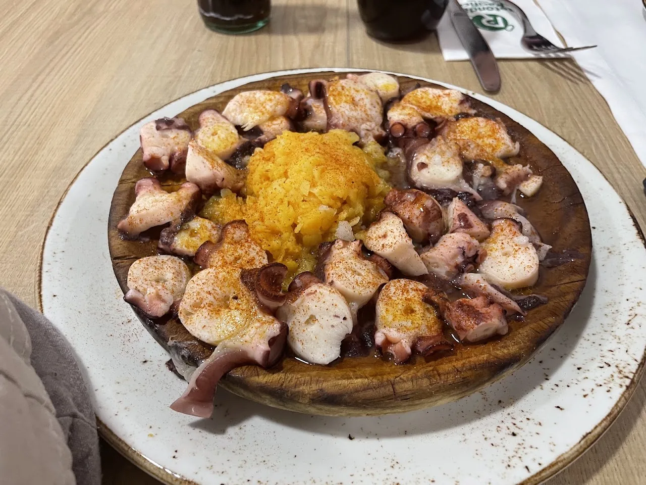 A plate of grilled octopus over saffron rice