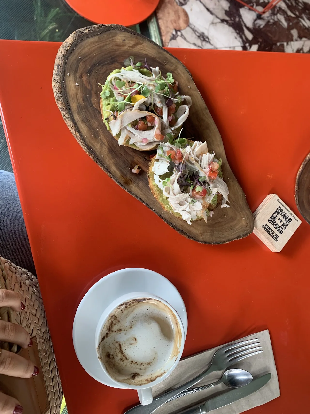 An overhead view of a wooden board with an open dish and a cup of coffee