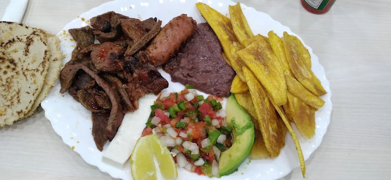 A plate of grilled meat, tortillas, avocado and pico de gallo