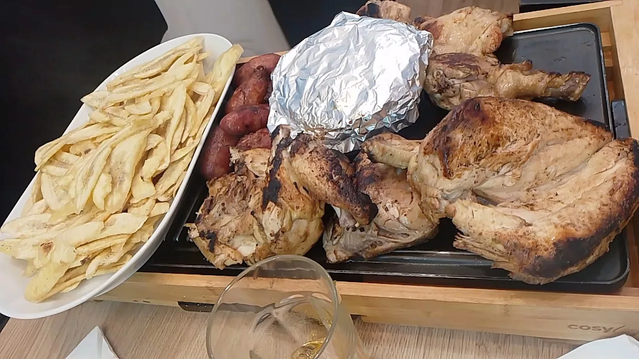 A platter of roasted chicken with grilled plantains and tortillas