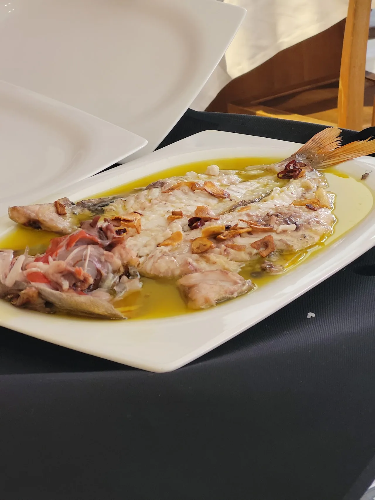 Grilled fish fillets in olive oil and herbs