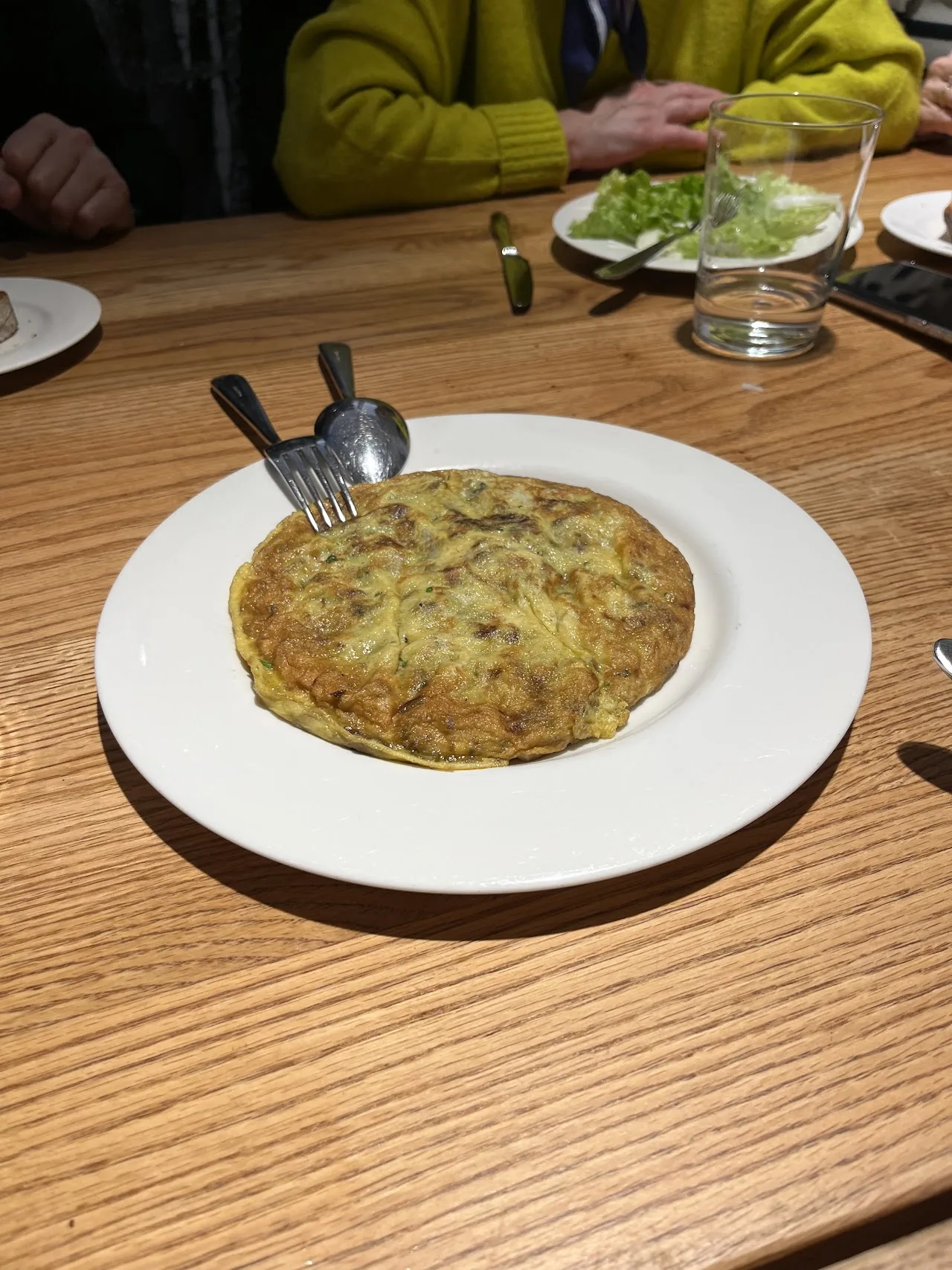 A round Spanish tortilla española on a white plate