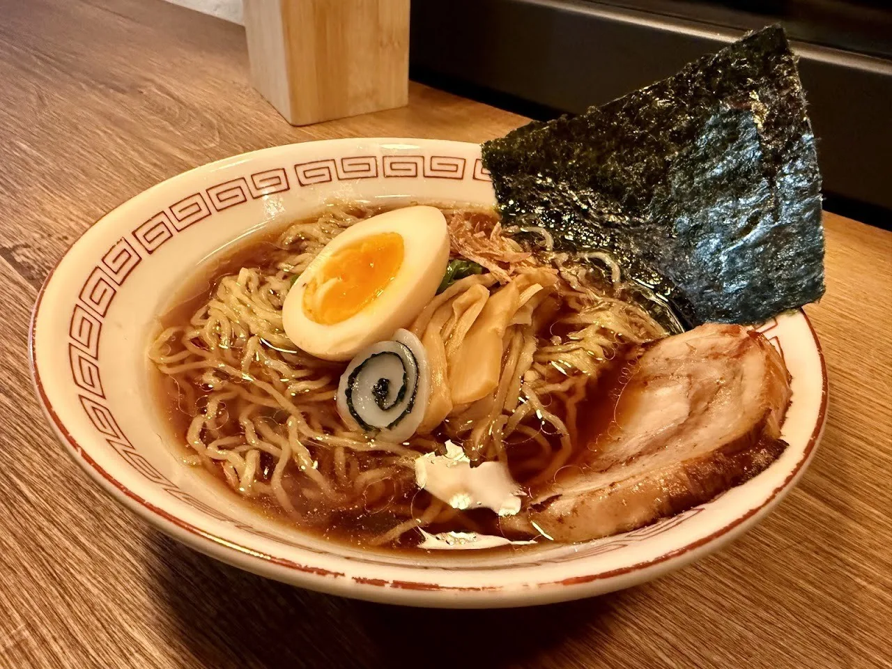 A bowl of ramen with a halved egg, nori and slices of pork