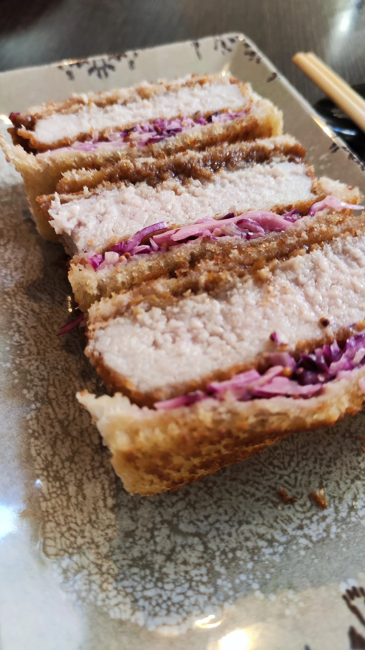 A sliced tonkatsu sandwich with shredded cabbage