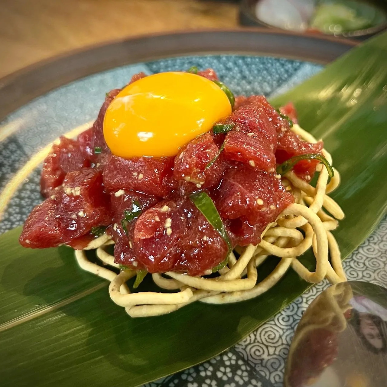 Tuna tartare with a raw egg yolk over noodles