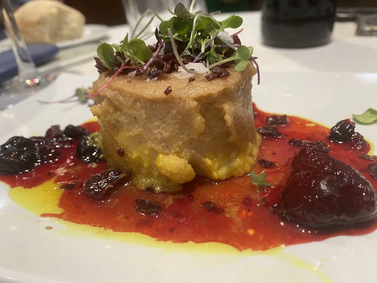 A terrine dish with a berry compote and microgreens