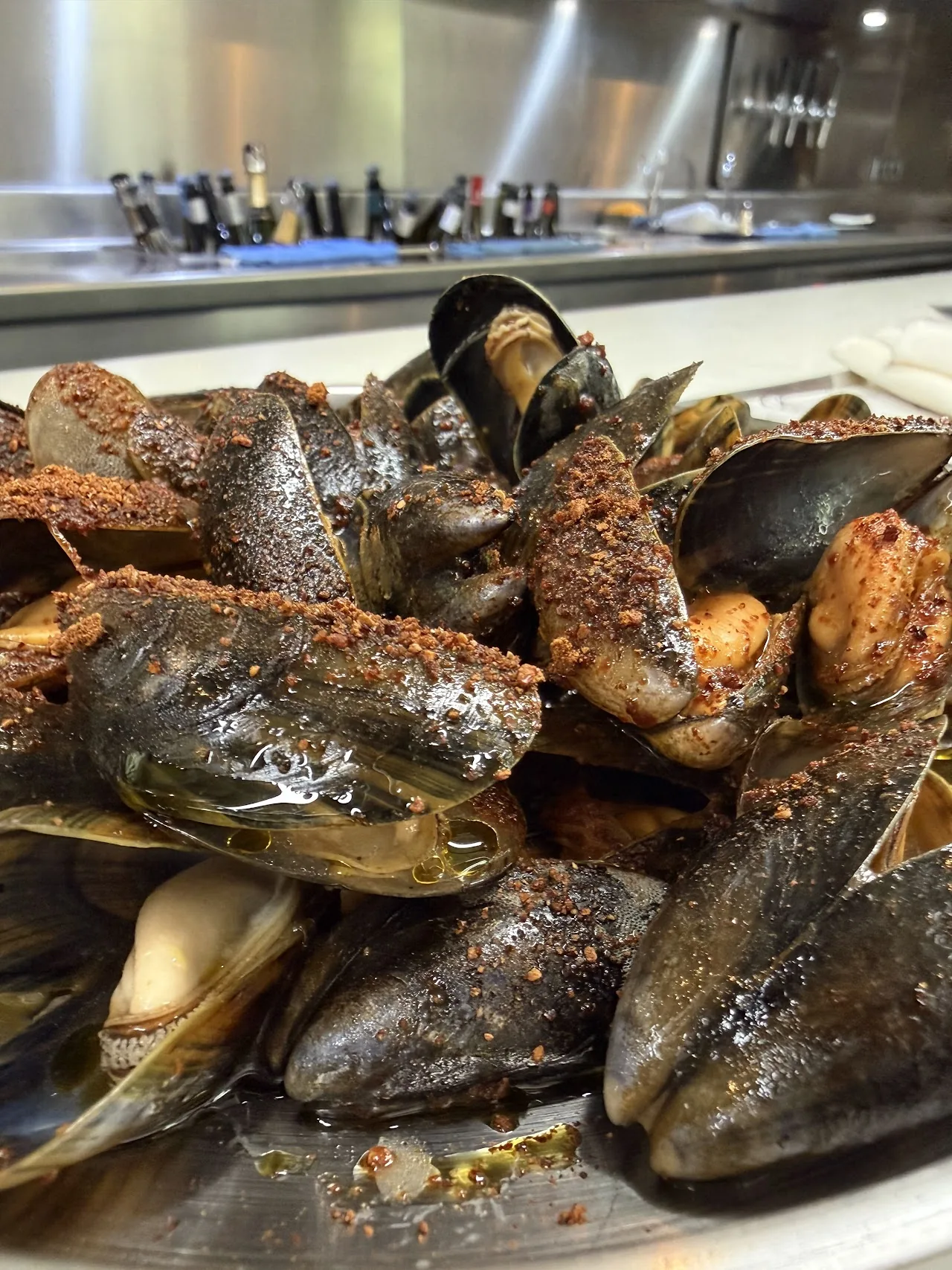 A pile of mussels on ice sprinkled with orange spice