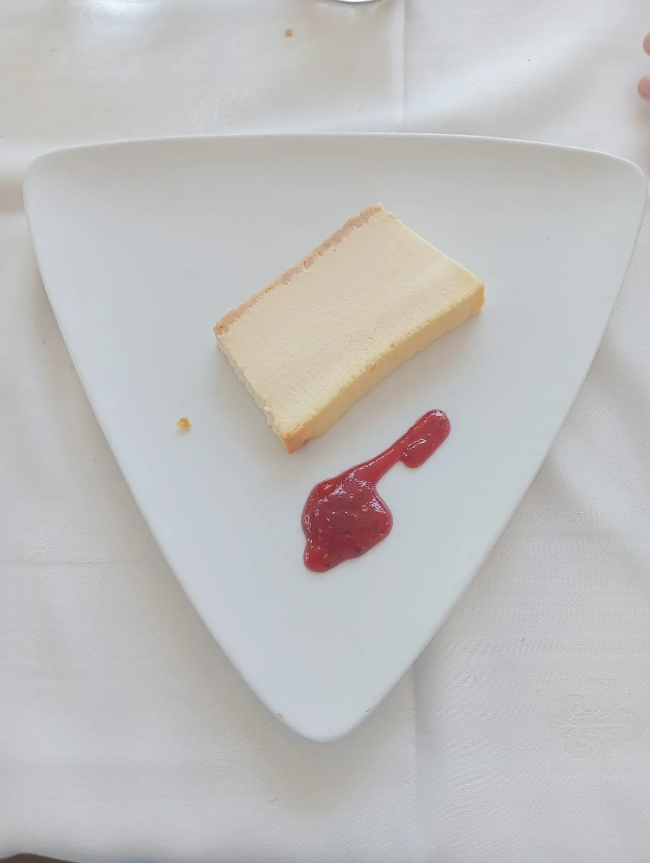 A slice of cheesecake with raspberry sauce