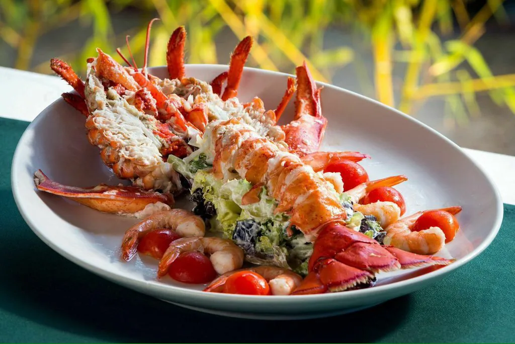 Grilled langoustines over a green salad with cherry tomatoes