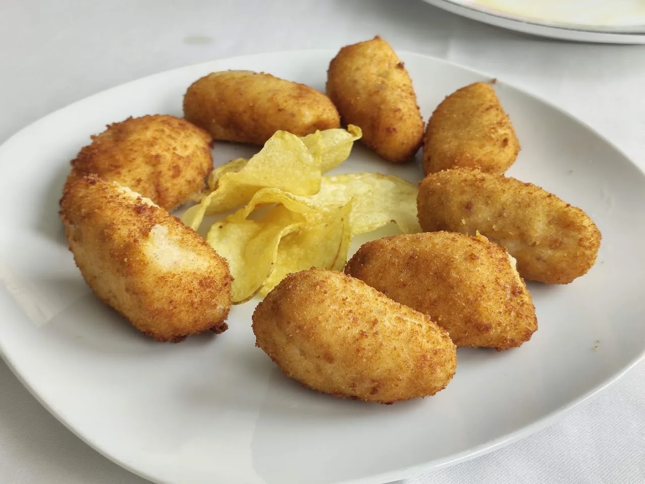 A plate of golden croquettes with crisps