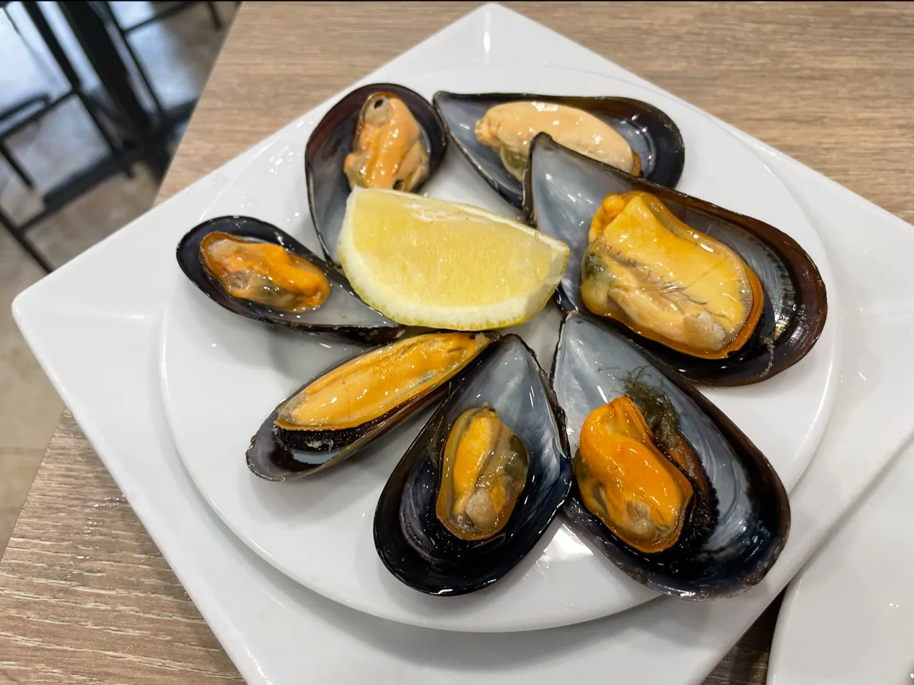 Steamed mussels on a plate with a lemon wedge