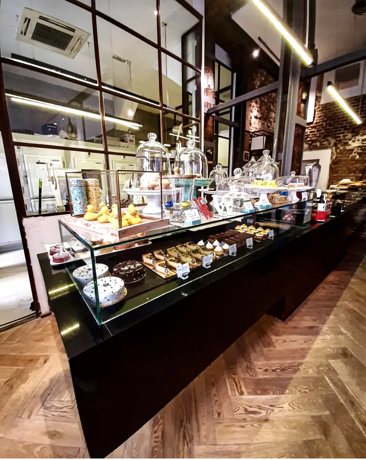 Glass pastry display case with whole cakes, tarts and individual pastries