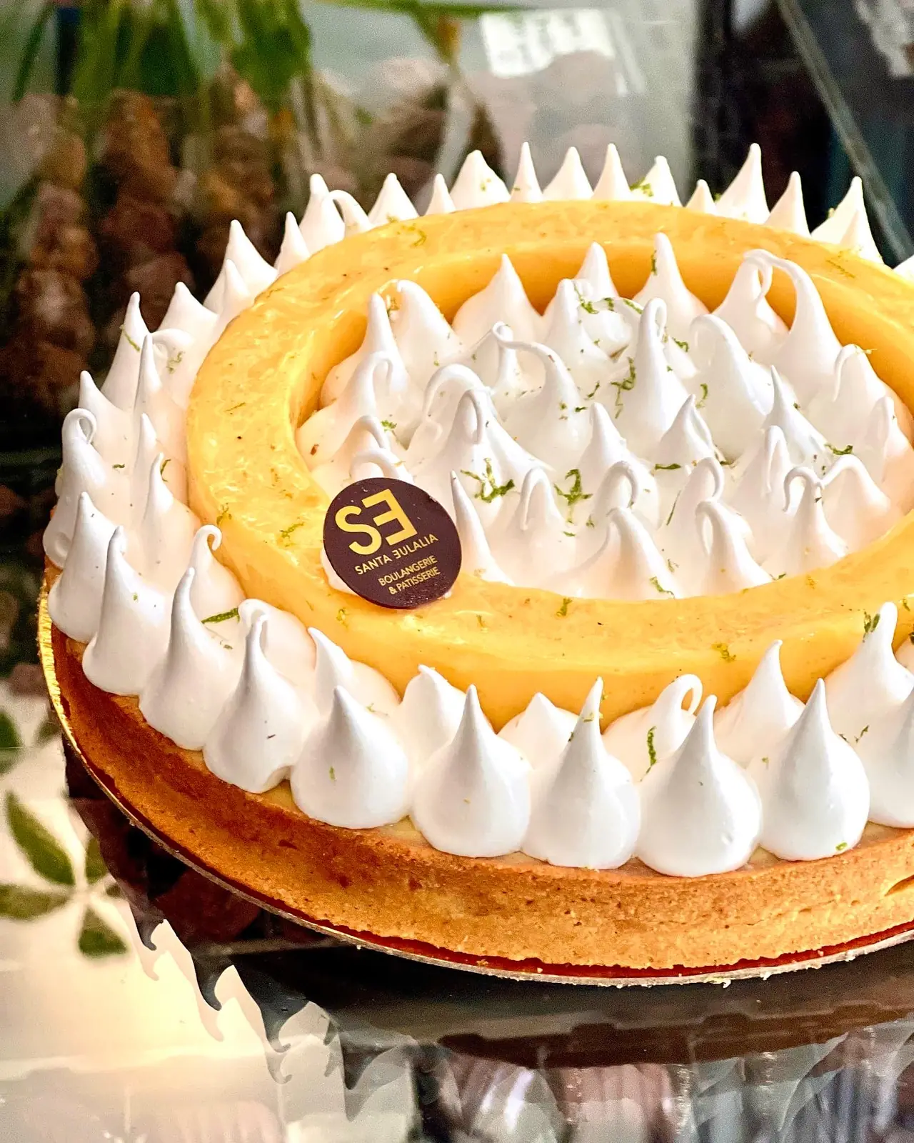 Lemon meringue tart with piped meringue peaks and lime zest, close-up
