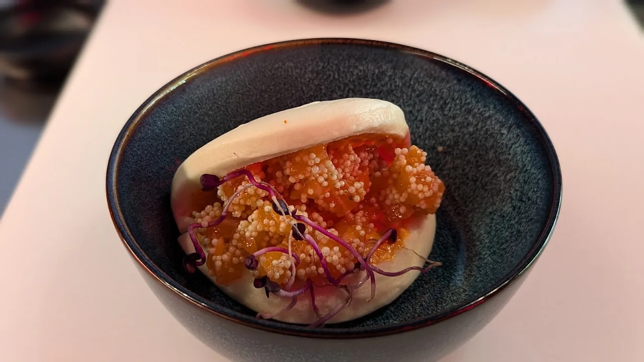 A bao bun filled with crispy chicken and micro greens