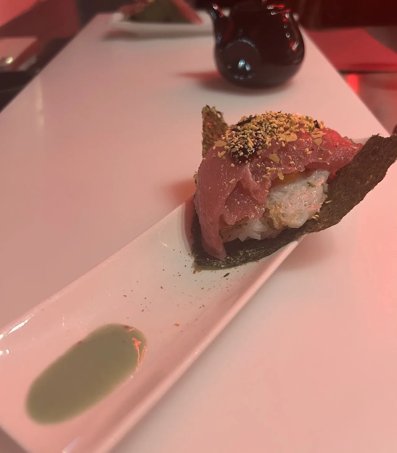 A piece of seared tuna tataki with sesame seeds on a cracker