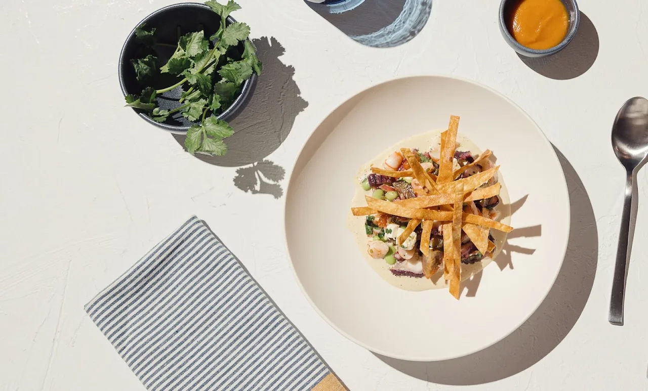 A plate of shoestring fries with a side salad