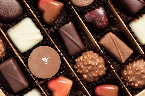 An assortment of filled chocolate bonbons in individual paper cups at Semon