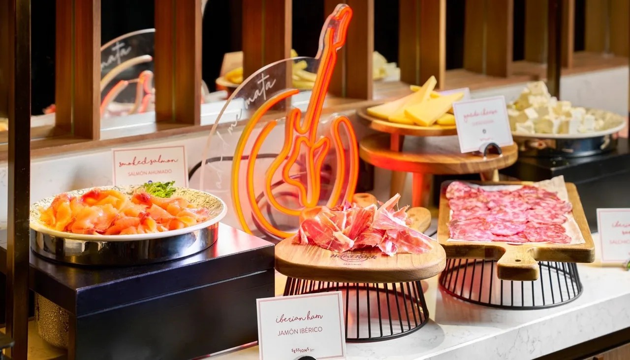 A buffet display of smoked salmon, sliced cured ham, cured sausage and cheeses