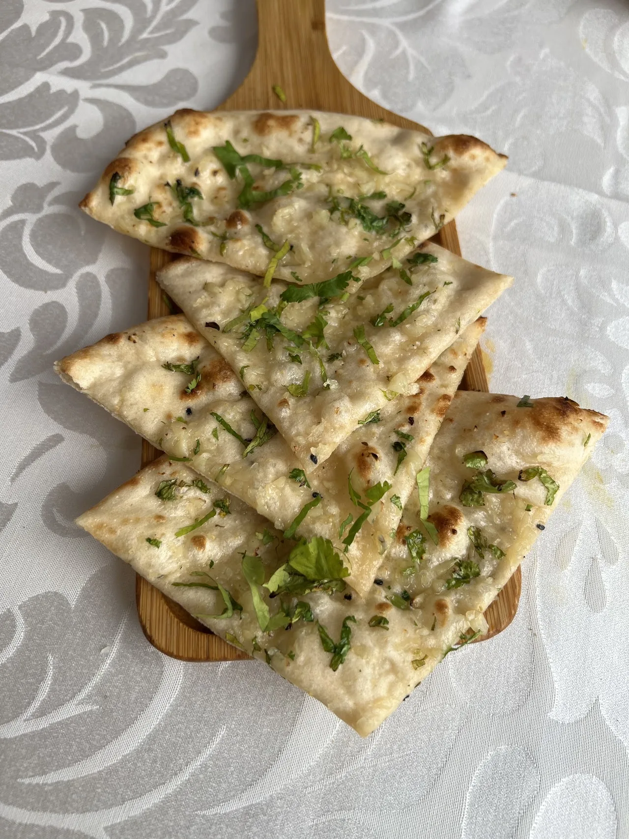 Wedges of naan bread garnished with herbs