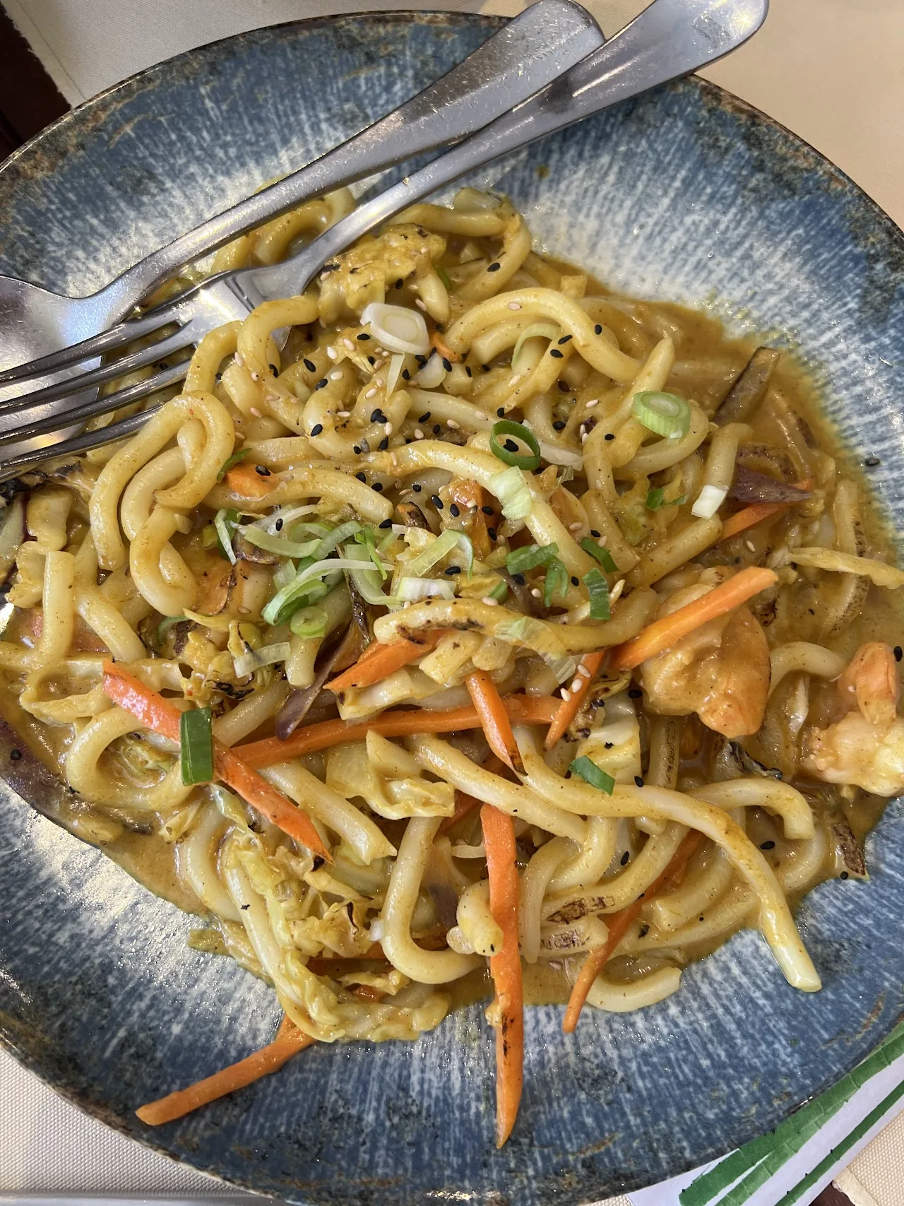 A bowl of stir-fried noodles with vegetables