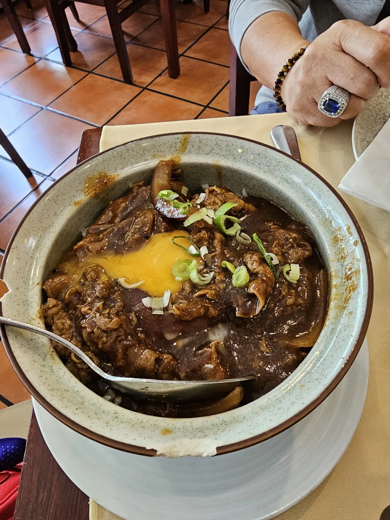 A clay pot of braised soup with a soft egg on top