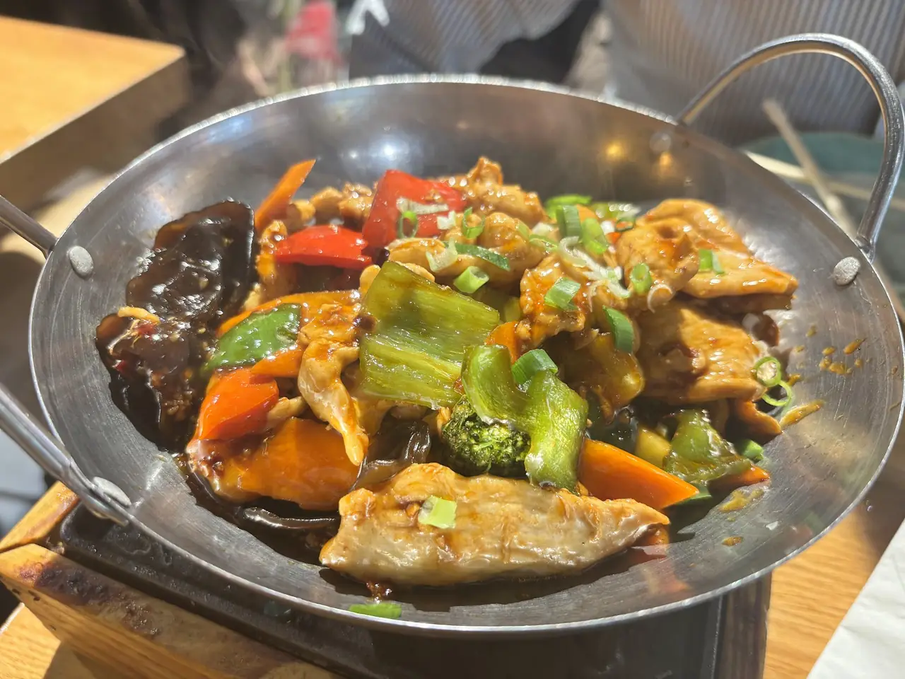 Wok stir-fry of chicken with bell peppers, carrots, broccoli and scallions in a savory sauce