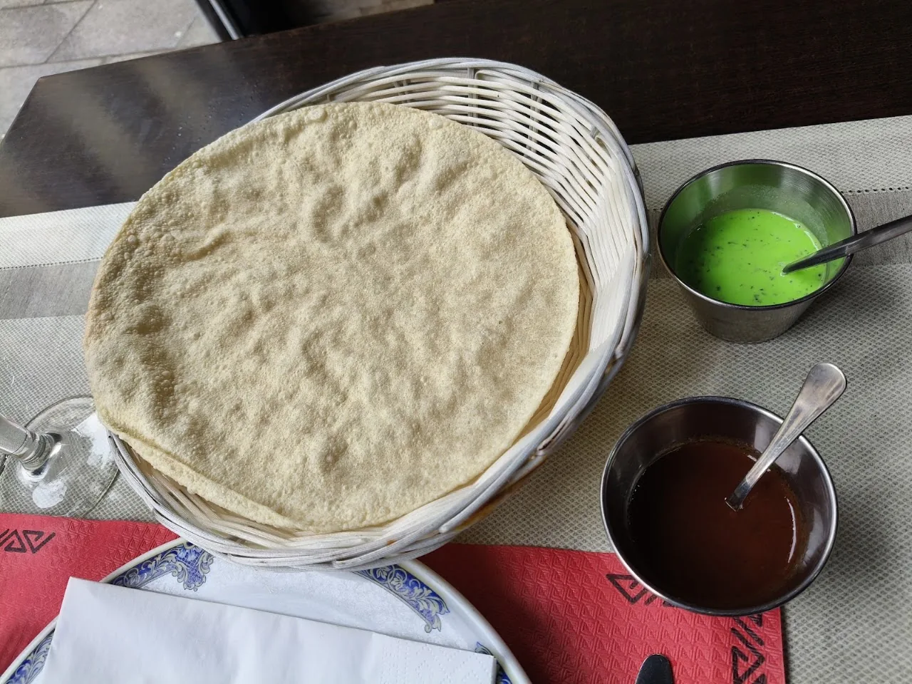 A basket of flatbreads with two dipping sauces