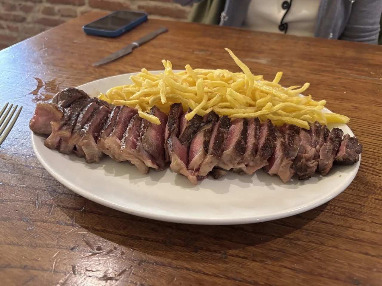 A sliced steak with a side of shoestring fries