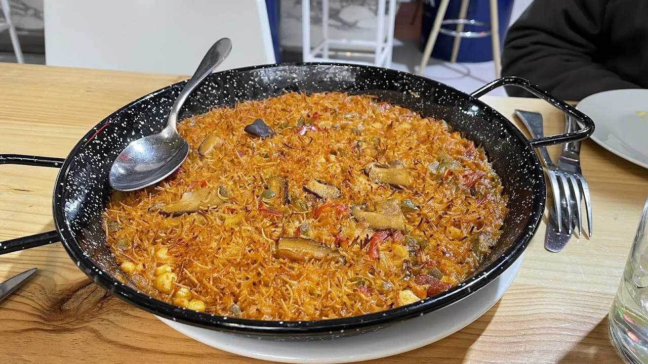 A pan of seafood paella with a serving spoon