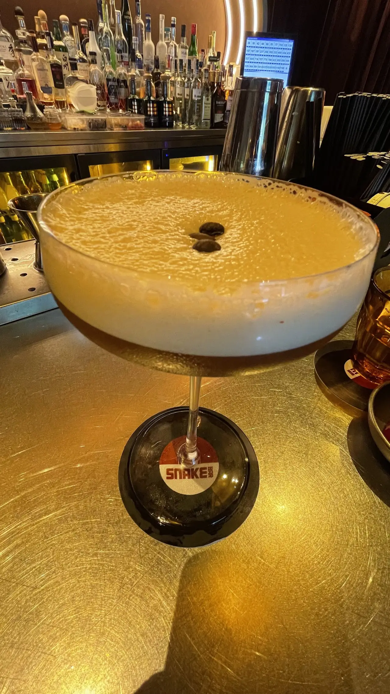 A frothy espresso-martini-style cocktail on the bar