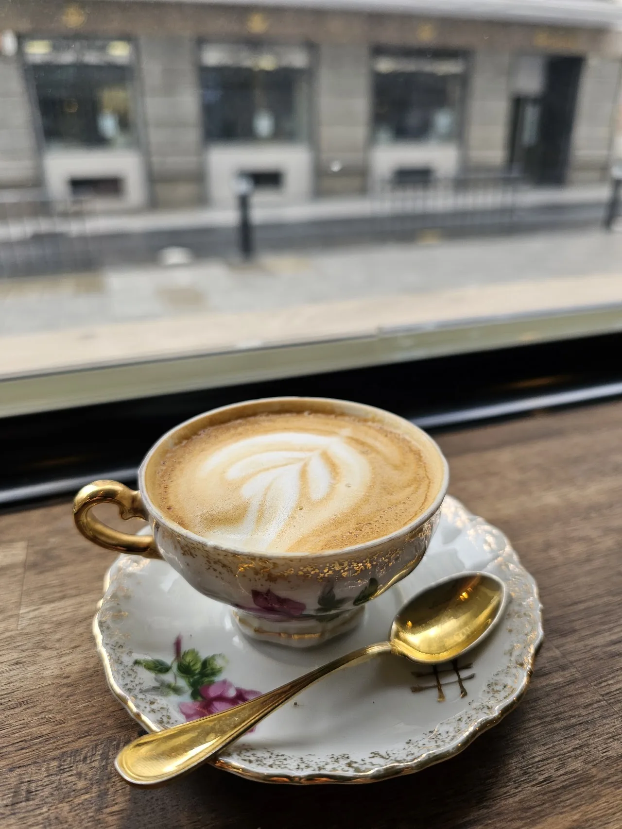 A cappuccino with heart-shaped latte art in a floral teacup