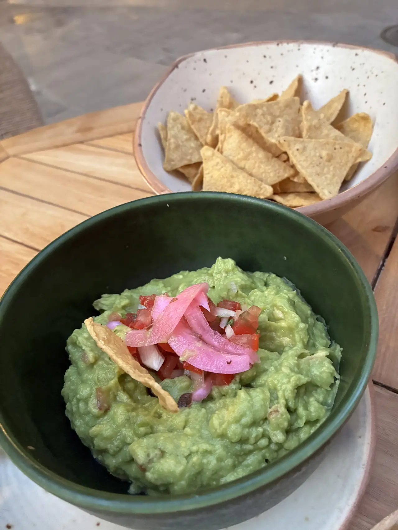 Guacamole topped with pickled onion and pico de gallo, served with tortilla chips
