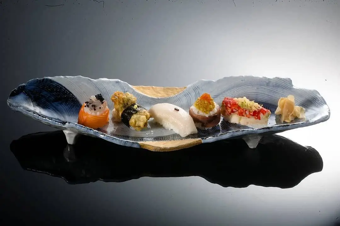 A tasting plate of small bites arranged along a curved stone slab.