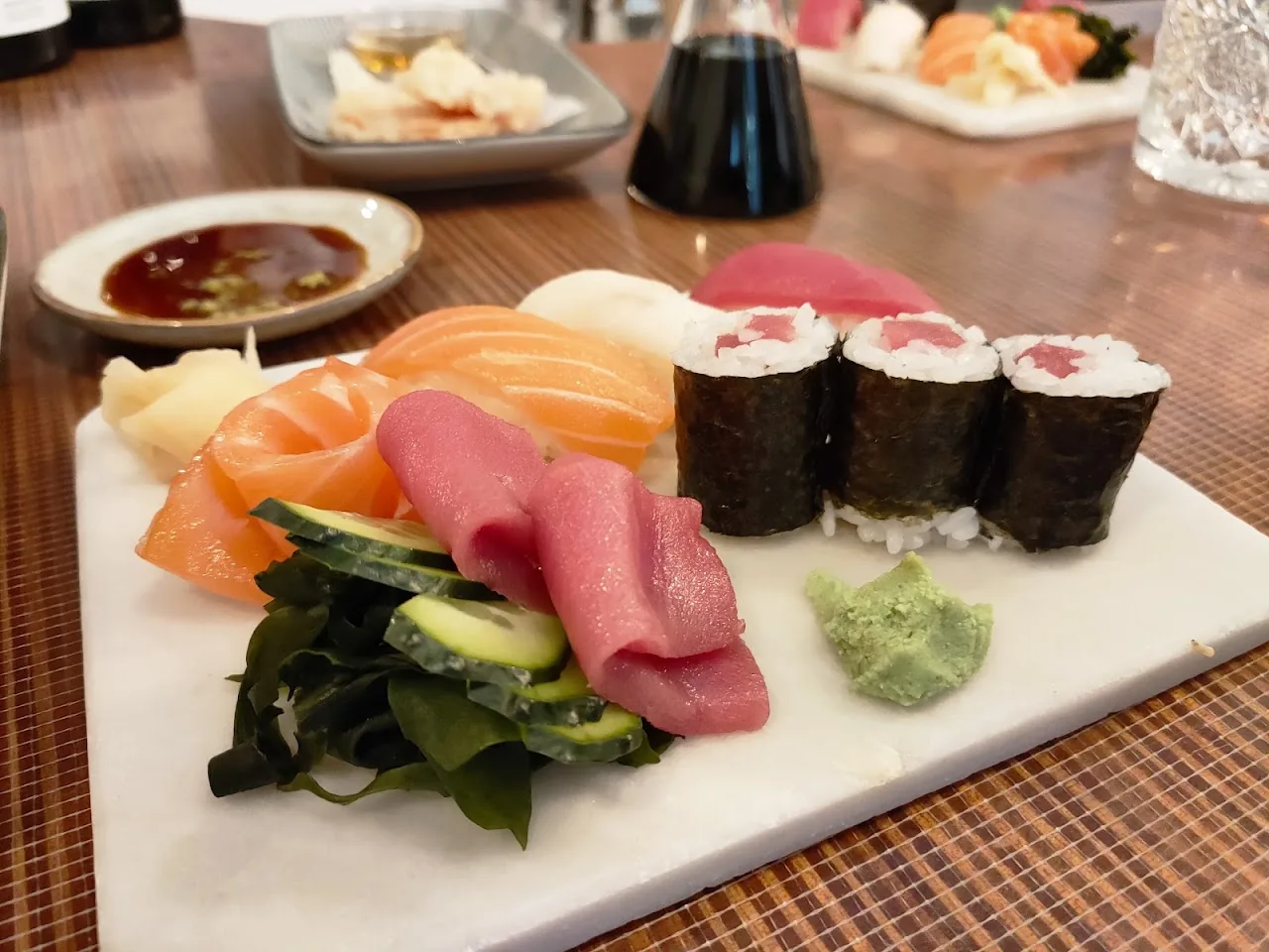 A platter of sashimi and maki rolls with wasabi and pickled ginger