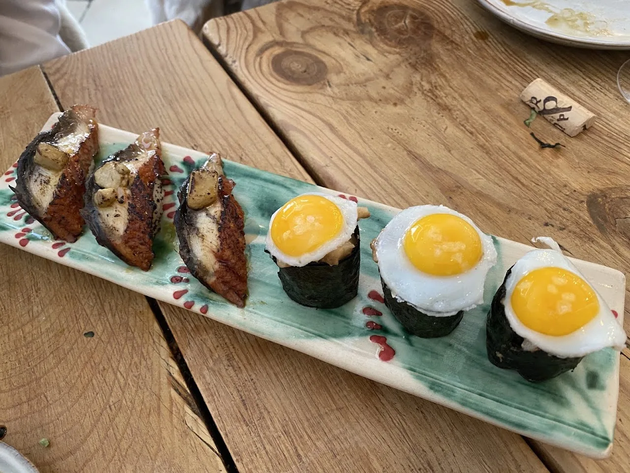 A row of nigiri topped with a raw egg yolk on each piece