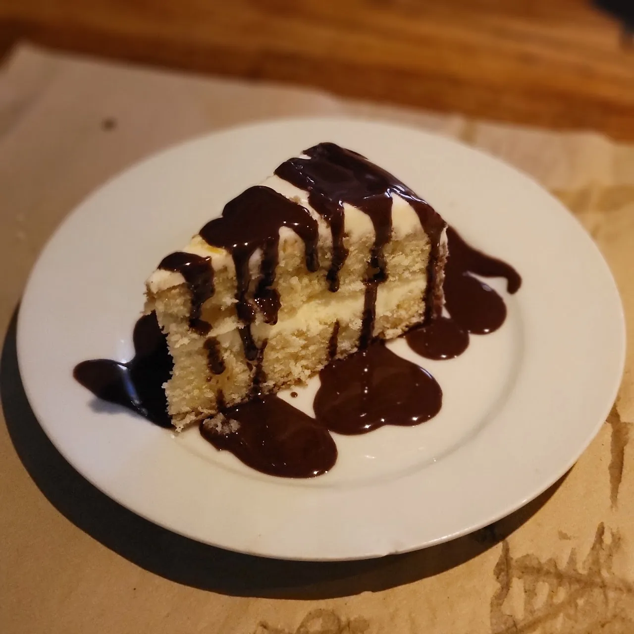 A slice of cake with chocolate sauce drizzled on top