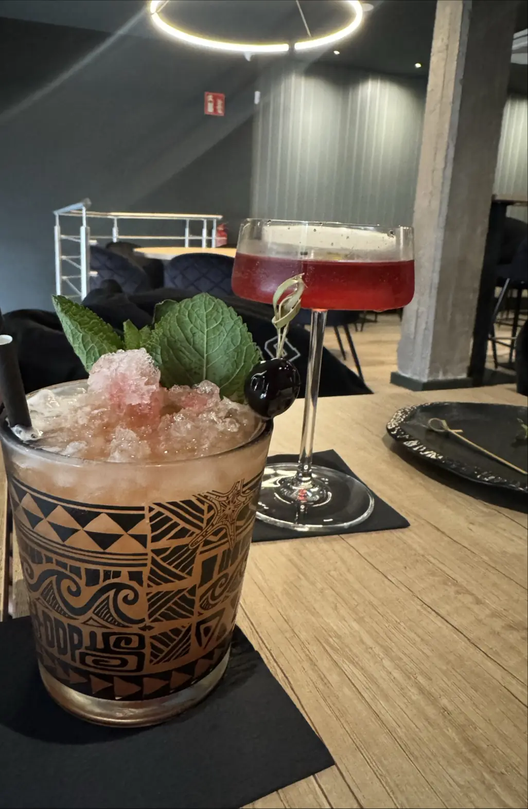A tiki-style cocktail with crushed ice and a mint garnish served in a carved mug.
