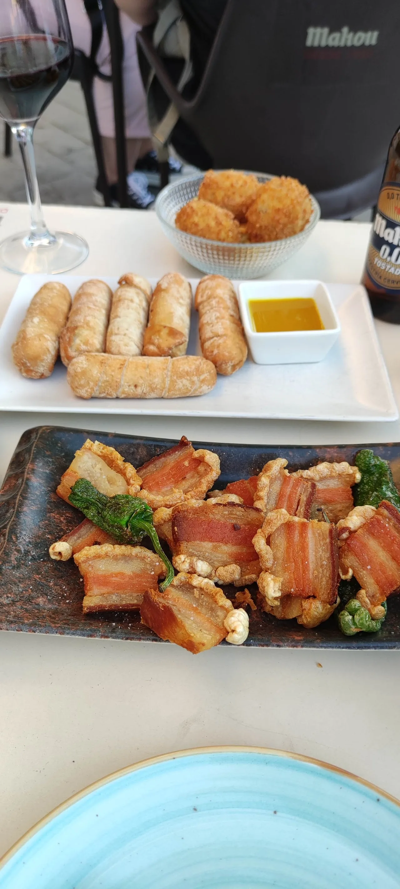 Fried croquettes with dipping sauce alongside a plate of tuna tartare bites