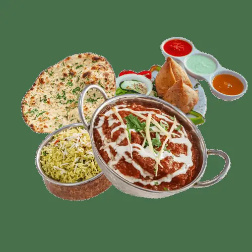 Indian food spread with garlic naan, tandoori chicken curry topped with cream and julienned ginger, saffron pulao rice, samosas, and three dipping sauces, at Swagatam Bar-Restaurant Hindu