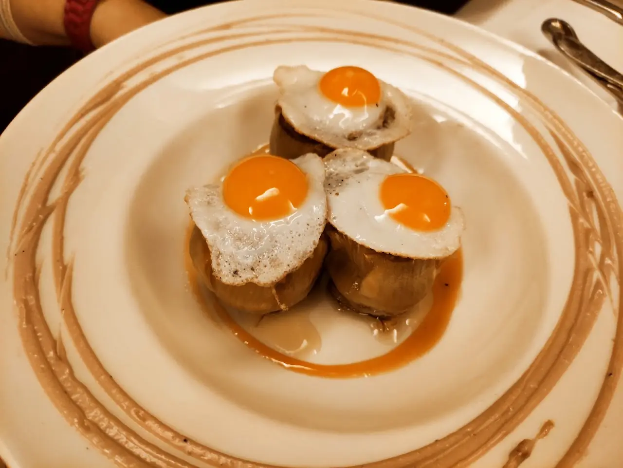 Toasts topped with small fried eggs on a floral-patterned plate