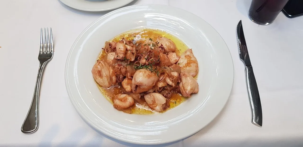 A plate of sliced octopus with olive oil and paprika