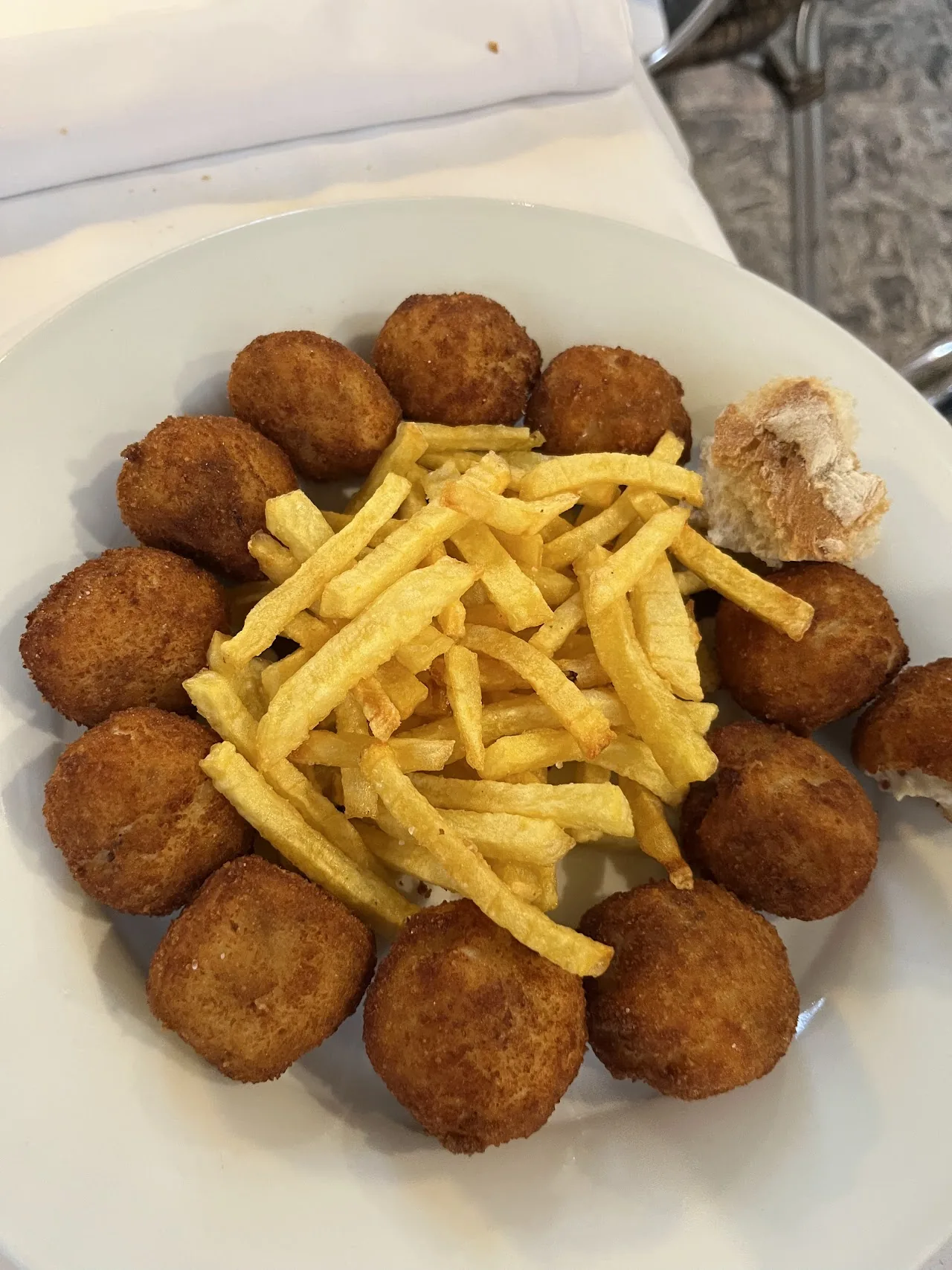 A plate of croquettes with a side of fried potato sticks